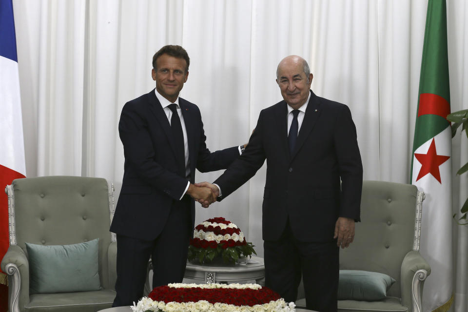 French President Emmanuel Macron, left, shakes hands with Algerian President Abdelmajid Tebboune before their talks, Thursday, Aug. 25, 2022 in Algiers. French President Emmanuel Macron is in Algeria for a three-day official visit aimed at addressing two major challenges: boosting future economic relations while seeking to heal wounds inherited from the colonial era, 60 years after the North African country won its independence from France. (AP Photo/Anis Belghoul)