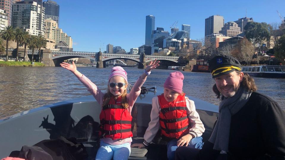 Owain Emslie and his two daughters in a boat in Melbourne. 