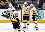 Pittsburgh Penguins forward Jake Guentzel (59), forward Evgeni Malkin (71), forward Sidney Crosby (87) and forward Bryan Rust (17) celebrate Crosby's second goal of the night against the Columbus Blue Jackets, during the third period of an NHL hockey game in Columbus, Ohio, Friday, Jan. 21, 2022. The Penguins won 5-2. (AP Photo/Paul Vernon)