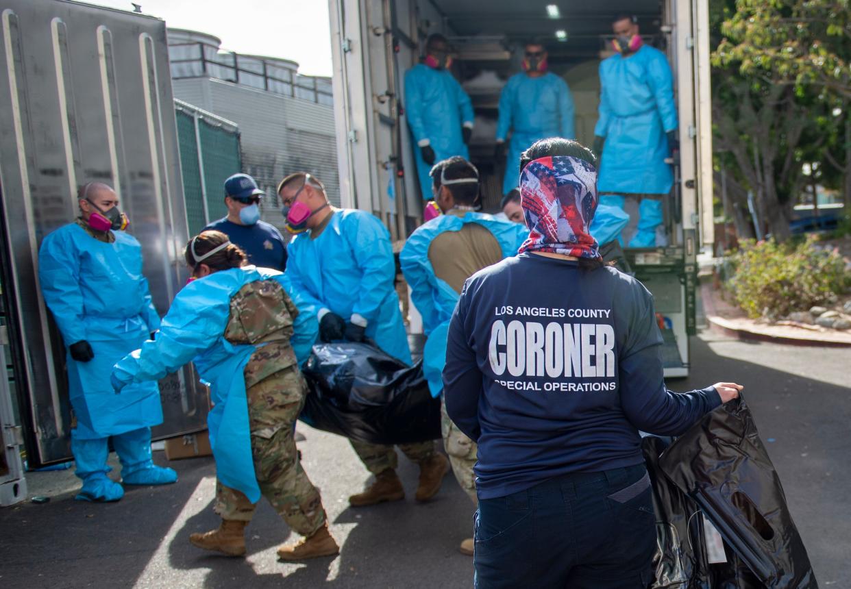 L.A. County Dept. of Medical Examiner-Coroner Elizabeth "Liz" Napoles, right, works alongside with National Guardsmen in 2020 to process the COVID-19 deaths to be placed into temporary storage at LA County Medical Examiner-Coroner Office in Los Angeles.