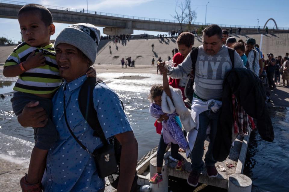 <p>A group of Central American migrants -mostly from Honduras- cross the shallow concrete waterway of the Tijuana River in an attempt to get to El Chaparral border crossing on the Mexico-US border, in Tijuana, Baja California State, Mexico, on November 25, 2018.</p>