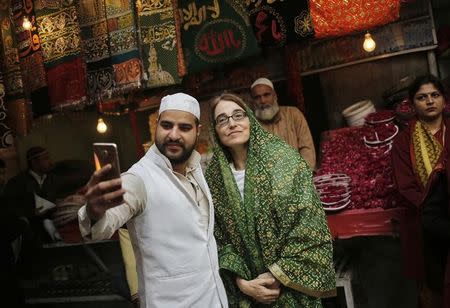 A Muslim cleric takes a selfie with Sarah Sewall (C), U.S. Under Secretary for Civilian Security, Democracy and Human Rights, during her visit to the shrine of Sufi Saint Nizamuddin Auliya in New Delhi, India, January 14, 2016. REUTERS/Anindito Mukherjee