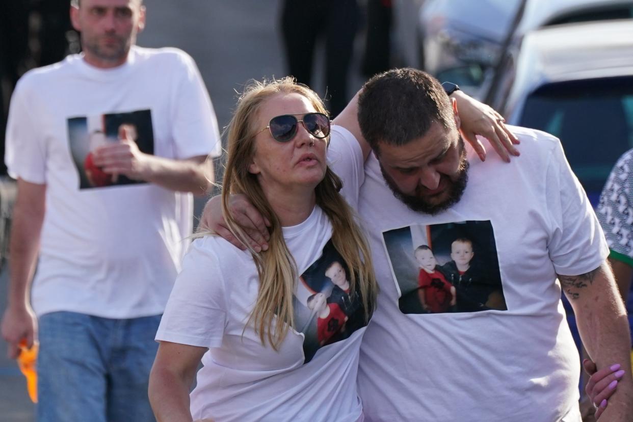 Many of those gathered at the vigil held blue balloons and wore white T-shirts adorned with pictures of the boys (PA)