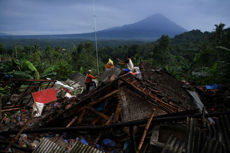People salvage their belongings from a house damaged by an earthquake in Lumajang