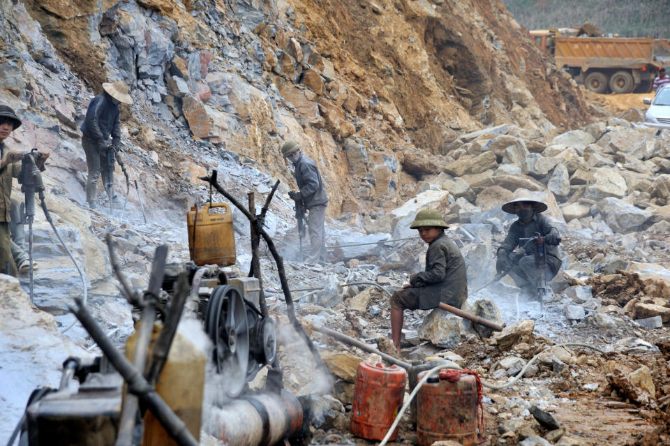 February 6: "Drilling the road" by louis.foecy.fr. 'We were driving along a road but reached this dead end - the car won't go any further as we needed to wait for the end of the road to be built. The construction site is rustic. The rocks are pulverized by hammers, the compressor has no tank and is replaced by an old can. There are no hard hats and no safety shoes because flip flops or sandals are enough.'