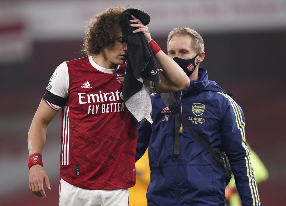 Arsenal's David Luiz holds a towel on a cut to his head following a clash with Wolverhampton Wanderers' Raul Jimenez during the English Premier League soccer match between Arsenal and Wolverhampton Wanderers at Emirates Stadium, London, Sunday, Nov. 29, 2020. (John Walton/Pool via AP)