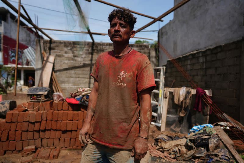 Omar Cruz, de 45 años, que perdió a un hermano durante el paso del huracán Otis, posa para una foto frente a su casa destruida en Acapulco