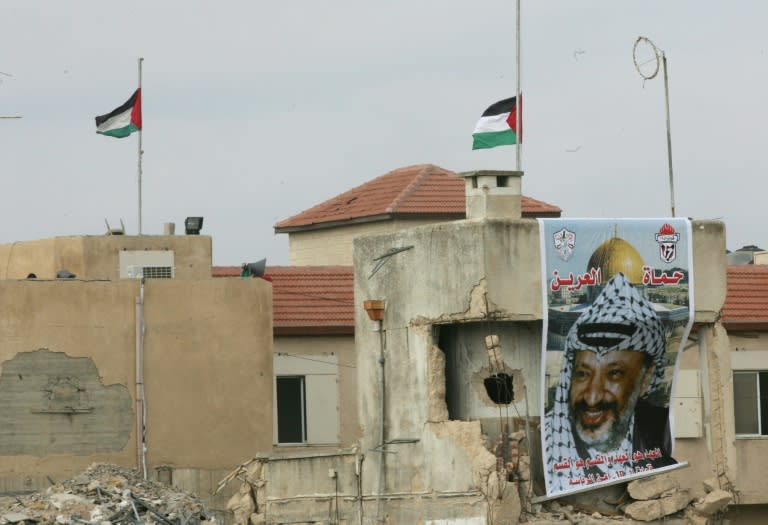 Flags fly at half-mast over the destroyed Muqataa compound after the death of Palestinian leader Yasser Arafat, November 11, 2004 at his West Bank headquarters, in Ramallah