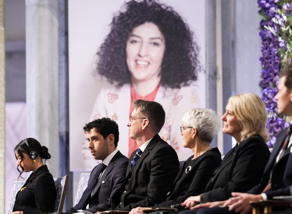 Ali and Kiana Rahmani, left, attend the awarding of the Nobel Peace Prize for 2023 to their mother, imprisoned Iranian activist Narges Mohammadi, in Oslo City Hall, Oslo, Norway, Sunday, Dec. 10, 2023. The children of Narges Mohammadi, shown on the screen, will accept this year’s Nobel Peace Prize on her behalf. Mohammadi is renowned for campaigning for women’s rights and democracy in her country. (Javad Parsa/NTB via AP)
