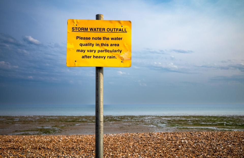 A sign warning people of the dangers from polluted water, especially after heavy rain, on the beach at Worthing, West Sussex, UK. Water companies in t
