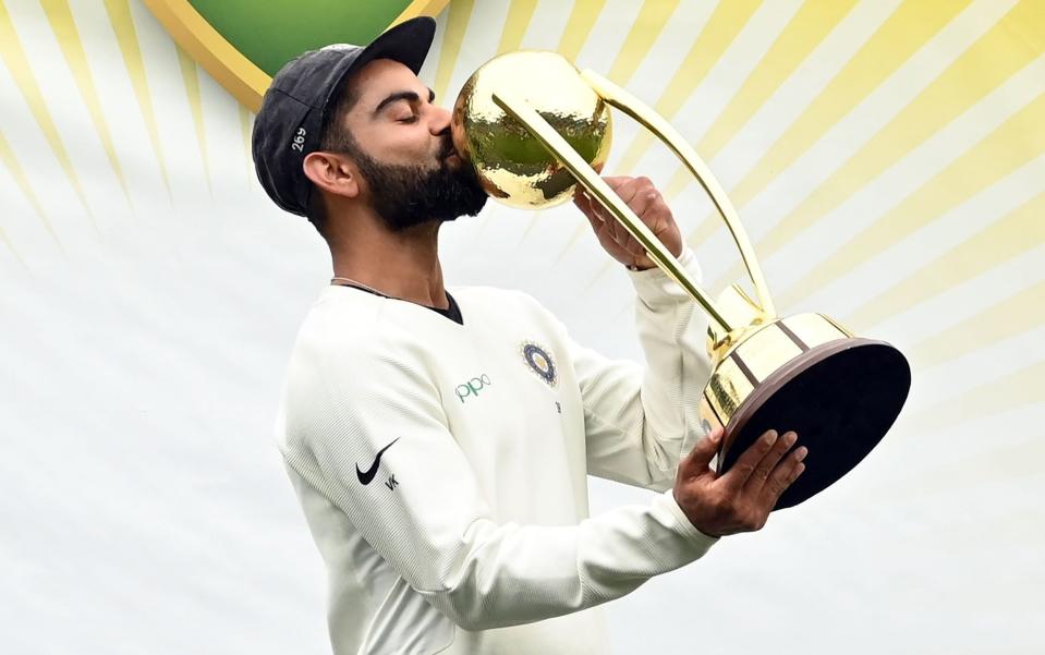 India's captain Virat Kohli kisses the Border-Gavaskar trophy as the Indian team celebrates their series win on the fifth day of the fourth and final cricket Test against Australia at the Sydney Cricket Ground in Sydney on January 7, 2019. - AFP