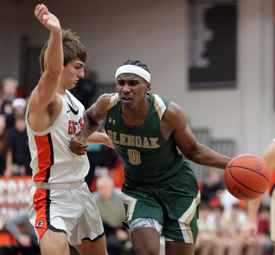 GlenOak Ja'Corey, Lipkins, right, drives to the basket against Green forward Samino Manson during the second half of a high school basketball game, Friday, Feb. 16, 2024, in Green, Ohio.