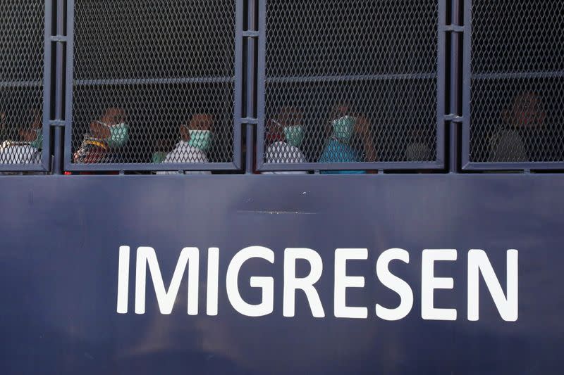 FILE PHOTO: Myanmar migrants to be deported from Malaysia are seen inside an immigration truck, in Lumut