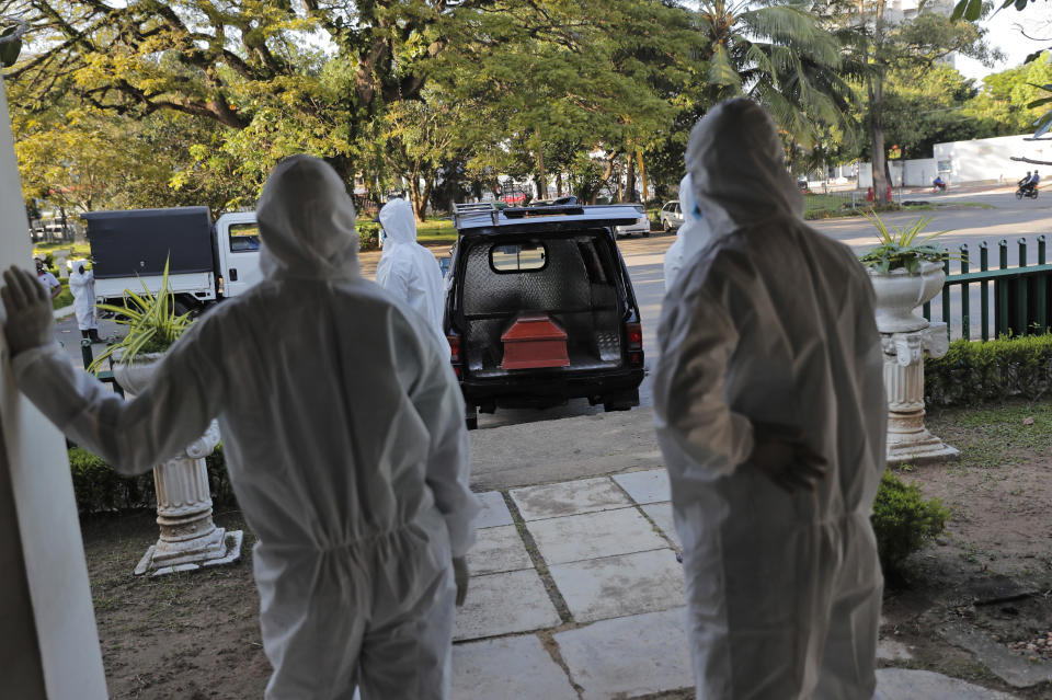 Sri Lankan municipal workers wait as they prepare to cremate a body of a COVID-19 victim at a cemetery in Colombo, Sri Lanka, Friday, Jan. 22, 2021. Sri Lanka on Friday approved the Oxford-AstraZeneca vaccine for COVID-19 amid warnings from doctors that front-line health workers should be quickly inoculated to stop the system from collapsing. (AP Photo/Eranga Jayawardena)