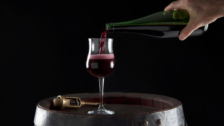 Person pouring Lambrusco red wine into glass