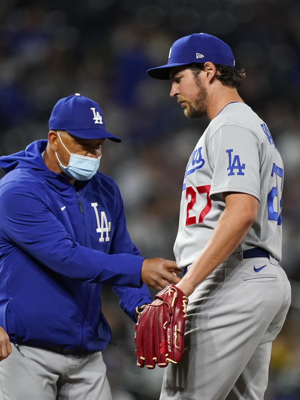 Los Angeles Dodgers manager Dave Roberts, left, takes the ball from starting pitcher Trevor Bauer after he struck out Colorado Rockies' Garrett Hampson in the seventh inning of a baseball game Friday, April 2, 2021, in Denver. (AP Photo/David Zalubowski)