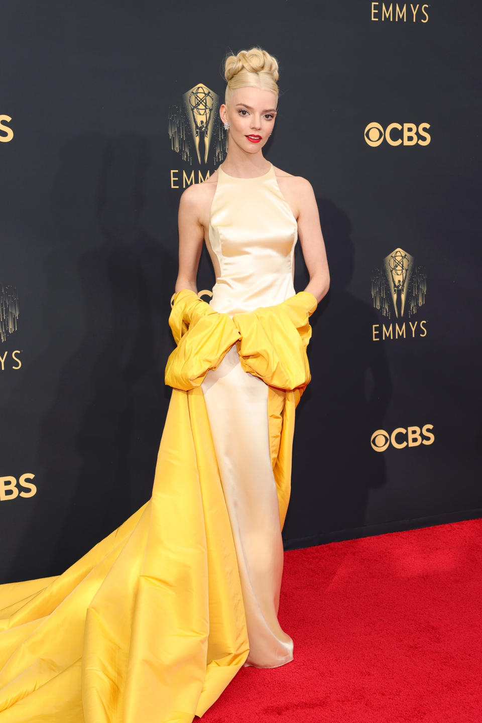 Anya Taylor-Joy wears a cream and yellow dress at the 73rd Primetime Emmy Awards at L.A. LIVE on September 19, 2021 in Los Angeles, California