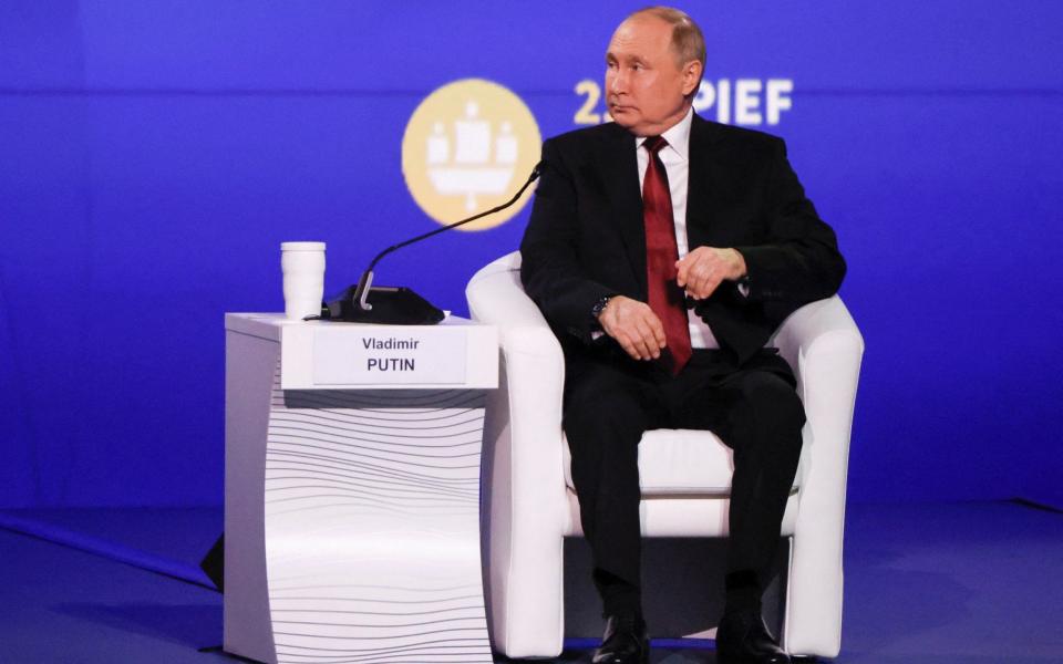 Putin waits to speak at the forum in St Petersburg on Friday - REUTERS