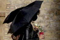 A woman holds an umbrella and a rose during a protest against tightening of Poland’s already restrictive abortion law, in front of the Polish Embassy in Rome, Wednesday, Oct. 28, 2020. Poland’s constitutional court declared that aborting fetuses with congenital defects is unconstitutional. Poland already had one of Europe’s most restrictive abortion laws, and the ruling will result in a near-complete ban on abortion. (Cecilia Fabiano/LaPresse via AP)