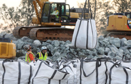 A load of rocks is lifted by a helicopter near the Lake Oroville Dam after an evacuation was ordered for communities downstream from the dam in Oroville, California, U.S. February 13, 2017. REUTERS/Jim Urquhart