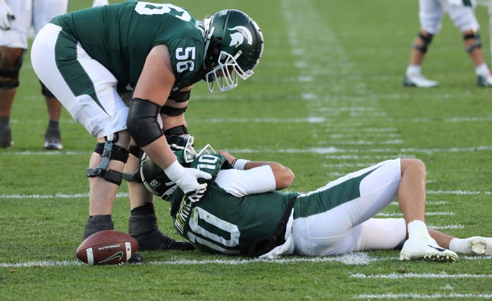 Michigan State Spartans guard Matt Carrick (56) helps  quarterback Payton Thorne (10) up after he was sacked during second half action against  the Ohio State Buckeyes  at Spartan Stadium Saturday, October 8, 2022.