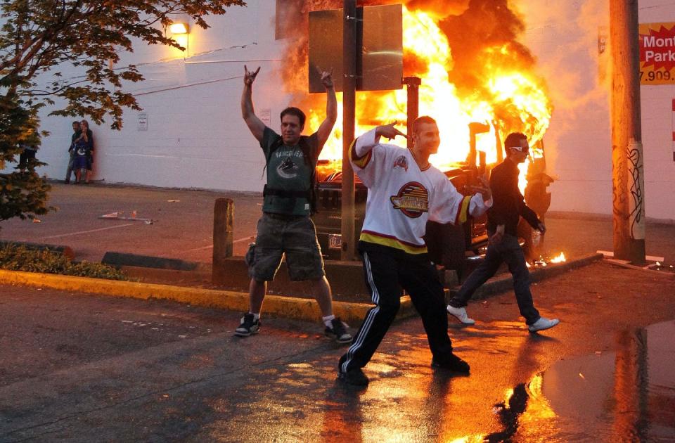 Fans revel in front of a car set ablaze.