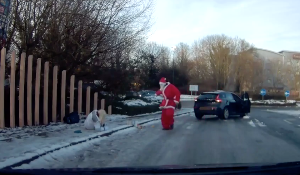 <em>Heroic rescue – When a pedestrian took a tumble on the ice, Santa himself hopped out of a car to rescue her (Pictures: Jukin Media)</em>