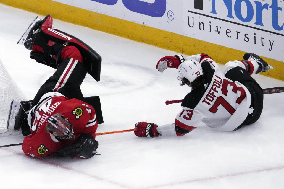 Chicago Blackhawks goaltender Arvid Soderblom, left, and New Jersey Devils right wing Tyler Toffoli, right, collide during the first period of an NHL hockey game in Chicago, Sunday, Nov. 5, 2023. (AP Photo/Nam Y. Huh)