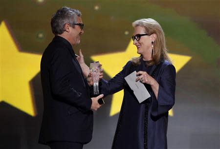 Director Alfosno Cuaron is presented with the award for best director by Meryl Streep at the 19th annual Critics' Choice Movie Awards in Santa Monica, California January 16, 2014. REUTERS/Mario Anzuoni