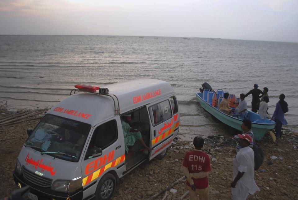 Rescue workers and volunteers gather to search bodies following a boat capsized in Kenjhar Lake, some 122 kilometers (75 miles) east of Karachi, Pakistan, Monday, Aug. 17, 2020. A small boat carrying members from a Pakistani family capsized in Keenjhar Lake in southern Sindh province on Monday, leaving some people dead and few missing, police said. (AP Photo/Pervez Masih)