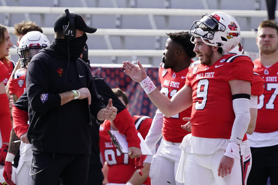 Ball State head coach Mike Neu and Ball State quarterback Drew Plitt (9) talk in the first half of the Arizona Bowl NCAA college football game against San Jose State, Thursday, Dec. 31, 2020, in Tucson, Ariz. (AP Photo/Rick Scuteri)