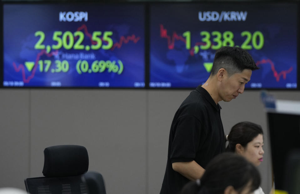 A currency trader watches monitors near the screens showing the Korea Composite Stock Price Index (KOSPI), top left, and the foreign exchange rate between U.S. dollar and South Korean won at the foreign exchange dealing room of the KEB Hana Bank headquarters in Seoul, South Korea, Friday, Aug. 18, 2023. (AP Photo/Ahn Young-joon)