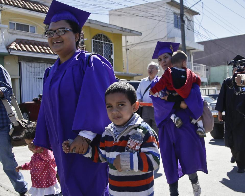 Angelica Lopez holds the hand of her son, Osmar, and daughter, Ashley, as they march with the group Border Dreamers and other supporters of an open border policy toward the United States border where some plan to ask for asylum Monday, March 10, 2014, in Tijuana, Mexico. (AP Photo/Lenny Ignelzi)