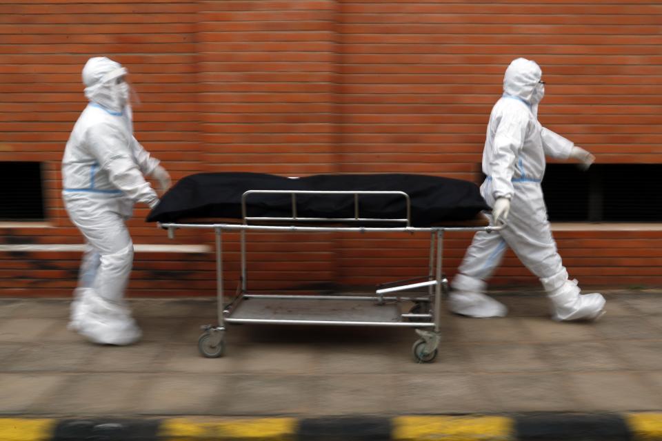 Nurses take the body of Isidra Coronel to the morgue after removing her body from a hospital bed where she died from COVID-19 at Hospital de Clinicas in San Lorenzo, Paraguay, Friday, June 18, 2021. According to the Health Ministry, Paraguay has South America's highest rate of COVID-19 related deaths per capita. (AP Photo/Jorge Saenz)