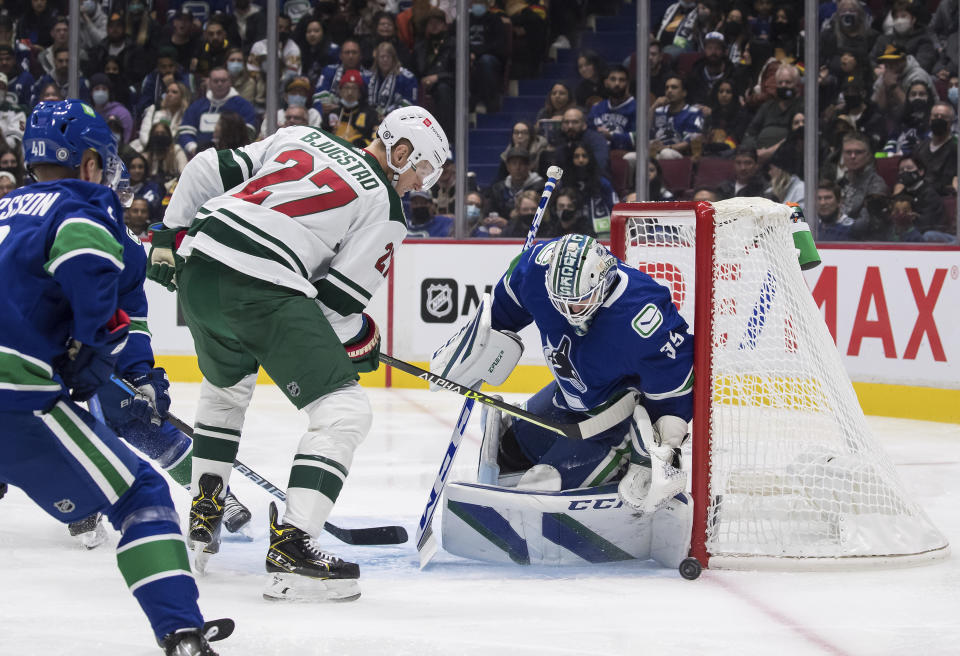 Vancouver Canucks goalie Thatcher Demko (35) stops Minnesota Wild's Nick Bjugstad (27) during the first period of an NHL hockey game, Tuesday, Oct. 26, 2021 in Vancouver, British Columbia. (Darryl Dyck/The Canadian Press via AP)