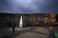 A man passes at Friendship Park, near where the border separating Tijuana, Mexico, and San Diego meets the Pacific Ocean Tuesday, Jan. 19, 2021, in Tijuana, Mexico. In the days before Joe Biden became president, construction crews worked quickly to finish Donald Trump's wall at an iconic cross-border park overlooking the Pacific Ocean that then-first lady Pat Nixon inaugurated in 1971 as symbol of international friendship. (AP Photo/Gregory Bull)