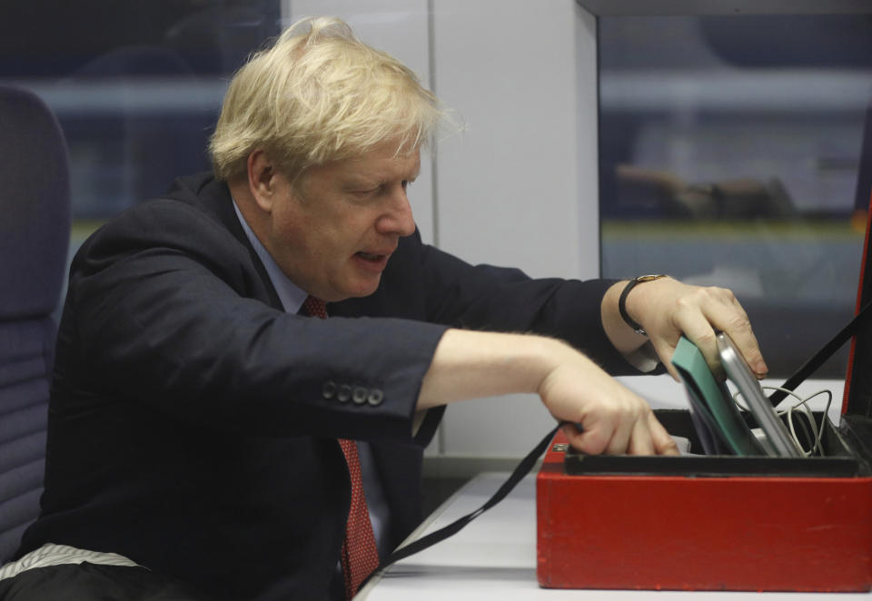 Britain's Prime Minister Boris Johnson sits on a train in London, Friday Dec. 6, 2019, on the campaign trail ahead of the general election on Dec. 12. Johnson pushed for the December vote, which is taking place more than two years early, in hopes of winning a majority and breaking Britain's political impasse over Brexit. (Peter Nicholls/Pool via AP)