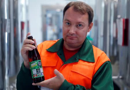 Chief brewer Alexei Saburov poses with a bottle of beer at the Melody Brew brewery in Polevskoy, Russia June 19, 2018. Picture taken June 19, 2018. REUTERS/Andrew Couldridge
