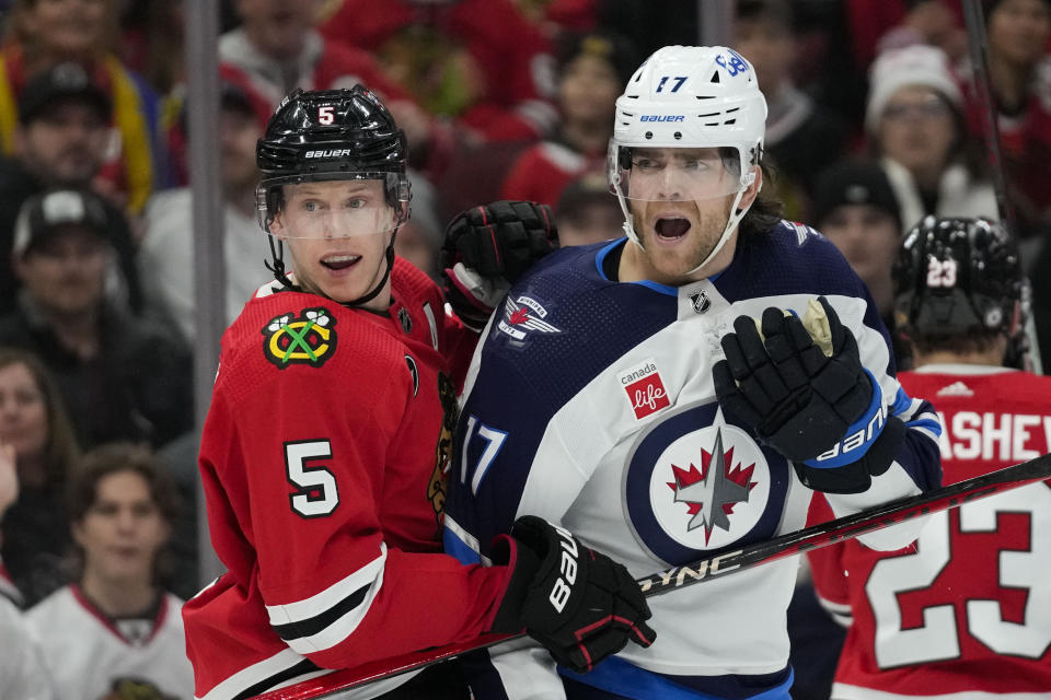 Winnipeg Jets center Adam Lowry, right, held by Chicago Blackhawks defenseman Connor Murphy, reacts to a goalie interference call during the second period of an NHL hockey game Wednesday, Dec. 27, 2023, in Chicago. (AP Photo/Erin Hooley)