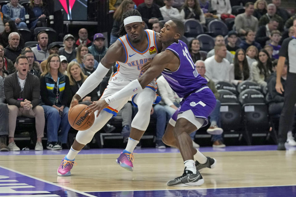 Oklahoma City Thunder guard Luguentz Dort, left, drives as Utah Jazz guard Kris Dunn (11) defends during the first half of an NBA basketball game Tuesday, Feb. 6, 2024, in Salt Lake City. (AP Photo/Rick Bowmer)