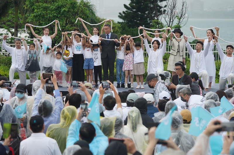 台灣民眾黨主席柯文哲（台上，中）20日上午在新北市滬尾藝文休閒園區舉行參選2024總統政見會，包含柯文哲妻子陳佩琪（前右4）、新竹市長高虹安（前右5）等人都出席，儘管一早就下起滂沱大雨，現場仍有許多支持者湧入。（中央社）