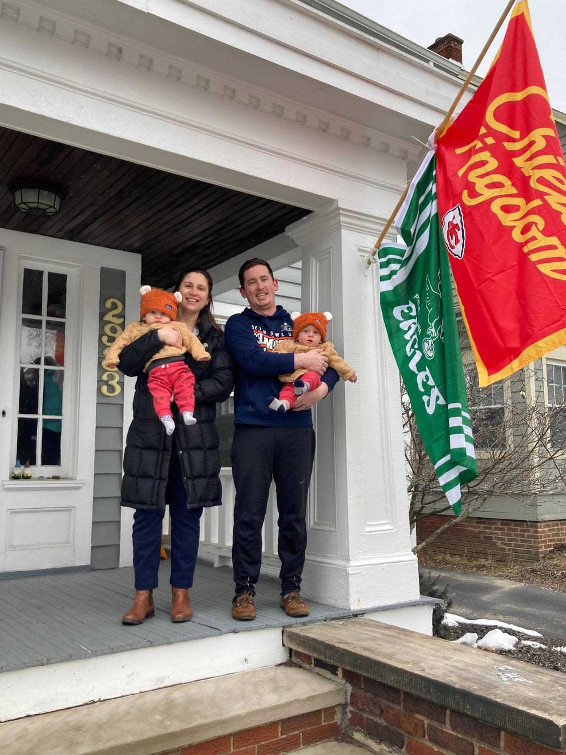 In a show of town spirit, Chiefs and Eagles flags hang from the boyhood home of Travis and Jason Kelce on Coleridge Road in Cleveland Heights, Ohio. Megan Ansbro and husband Levi Heacock, seen with twin sons Henry, left, and Hugo, moved there in August.