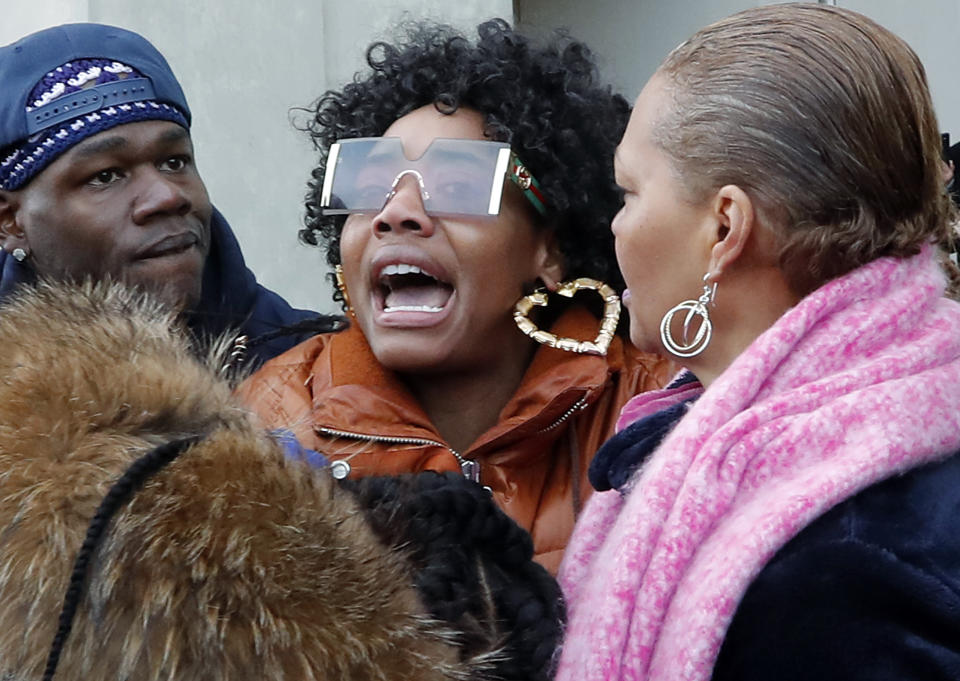 Yandy Smith, center, gasps for air as people come to her aid after she was sprayed with pepper spray and thrown to the ground after storming the main entrance of the Metropolitan Detention Center, a federal prison with all security levels, during a demonstration with protesters and prisoners' family members, Sunday, Feb. 3, 2019, in New York. The prison has been without heat, hot water, electricity and sanitation since earlier in the week, including through the recent frigid weather. (AP Photo/Kathy Willens)