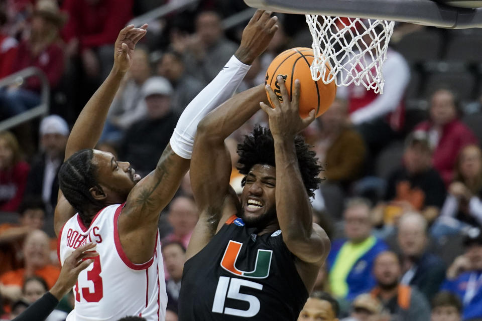 Miami forward Norchad Omier vies for the ball with Houston forward J'Wan Roberts in the first half of a Sweet 16 college basketball game in the Midwest Regional of the NCAA Tournament Friday, March 24, 2023, in Kansas City, Mo. (AP Photo/Charlie Riedel)