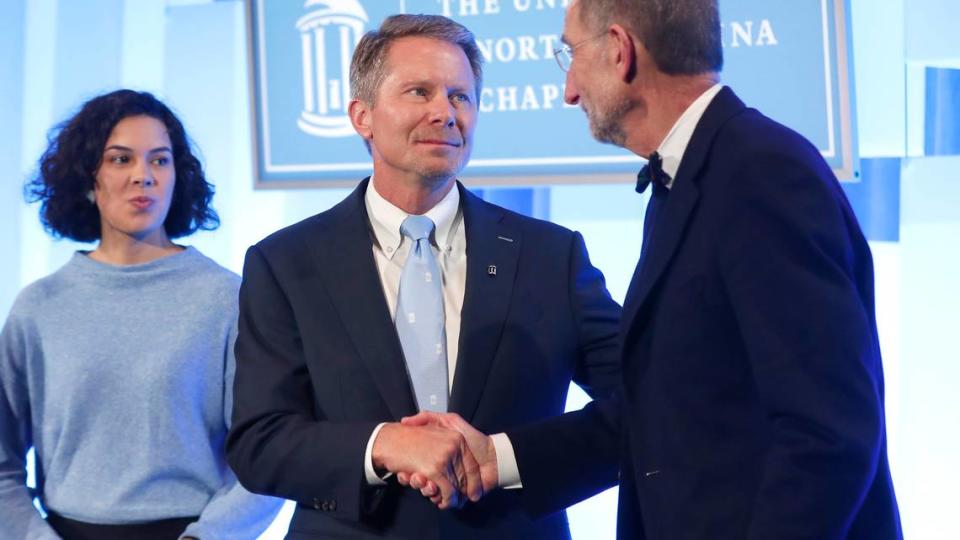 UNC System Interim President Bill Roper, right, shakes hands with Kevin Guskiewicz after a ceremony in Chapel Hill, N.C. celebrating Guskiewicz being named chancellor of UNC-Chapel Hill Friday, Dec. 13, 2019. Ethan Hyman/ehyman@newsobserver.com