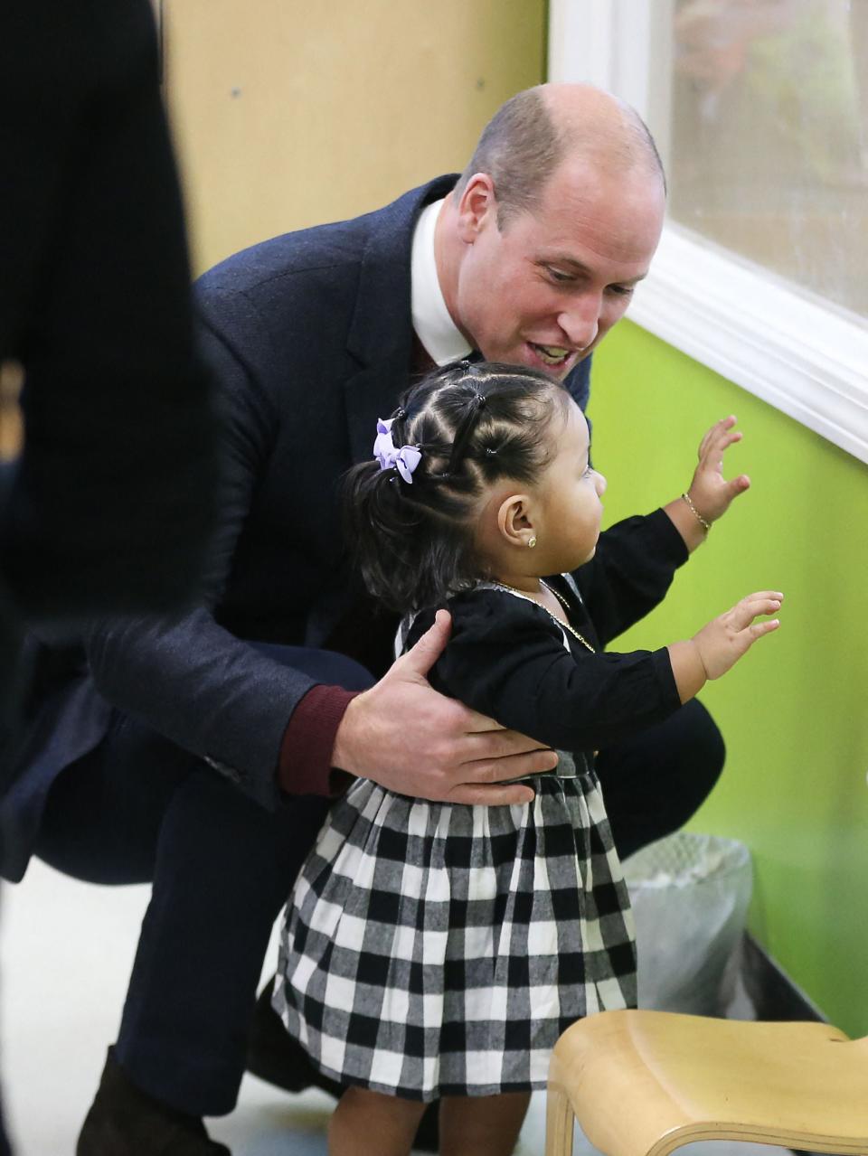 Britain's Prince William, Prince of Wales, engages with 16-month-old Sofia during a visit to Roca Inc, an organization working to reduce urban violence through community engagement efforts, in Chelsea, Massachusetts, on December 1, 2022 (POOL/AFP via Getty Images)