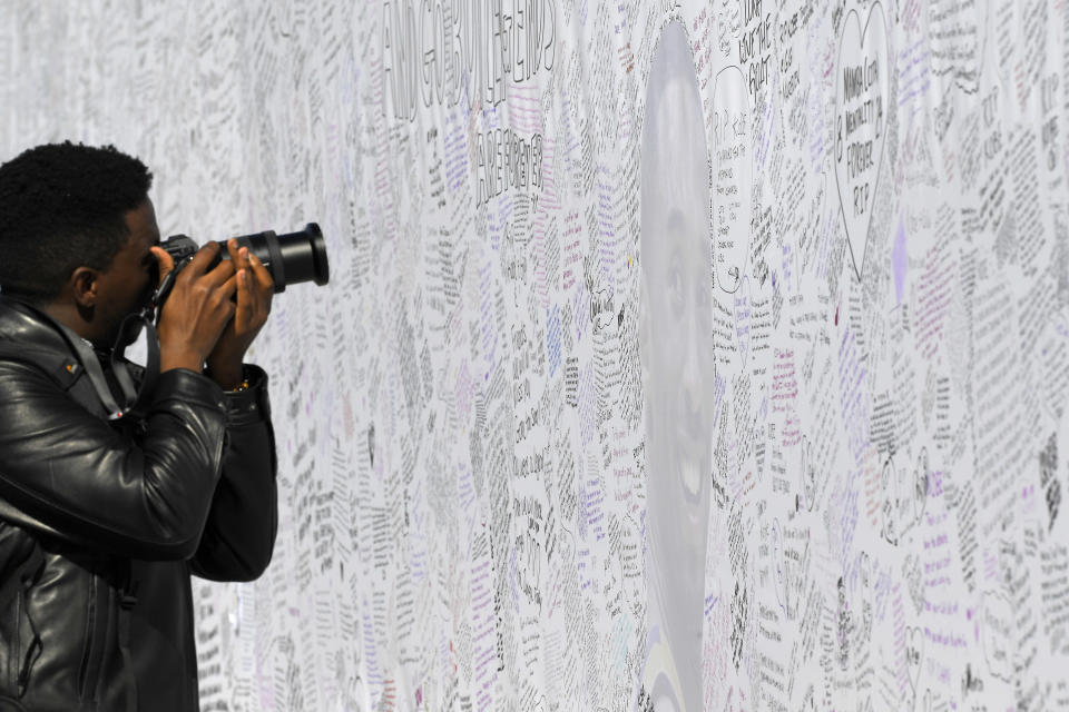 A fan takes a picture of a memorial for former Los Angeles Lakers player Kobe Bryant at NBA basketball team's practice facility Wednesday, Jan. 29, 2020, in El Segundo, Calif. Bryant, his 13-year-old daughter, Gianna, and seven others died in a helicopter crash on Sunday, Jan. 26. (AP Photo/Mark J. Terrill)