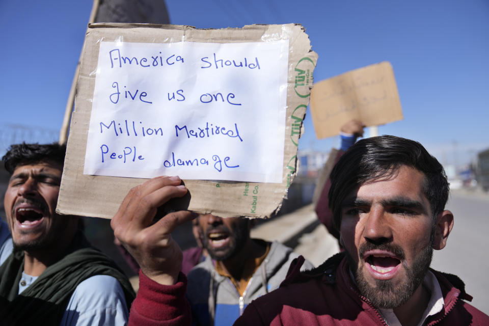 Afghan protesters hold placards and shout slogans against U.S. during a protest condemning President Joe Biden's decision, in Kabul, Afghanistan, Saturday, Feb. 12, 2022. President Biden signed an executive order, Friday, Feb. 11, 2022, to create a pathway to split $7 billion in Afghan assets frozen in the U.S. to fund humanitarian relief in Afghanistan and to create a trust fund to compensate Sept. 11 victims. (AP Photo/Hussein Malla)