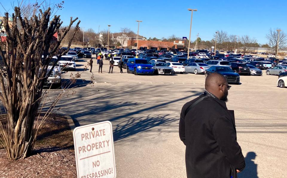 A private security detail patrols the parking lot of the New Direction Christian Church during funeral services for Anthony "Big Jook" Mims.