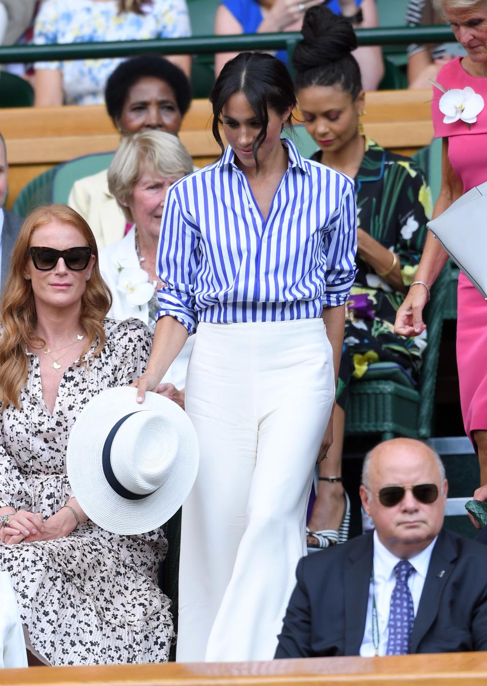 While it’s been reported that Queen Elizabeth II prefers women in the family to choose dresses and skirts for official appearances, Meghan opted for a pair of white pants and a striped shirt from Ralph Lauren for this most recent Wimbledon match, which she attended with sister-in-law Kate Middleton.